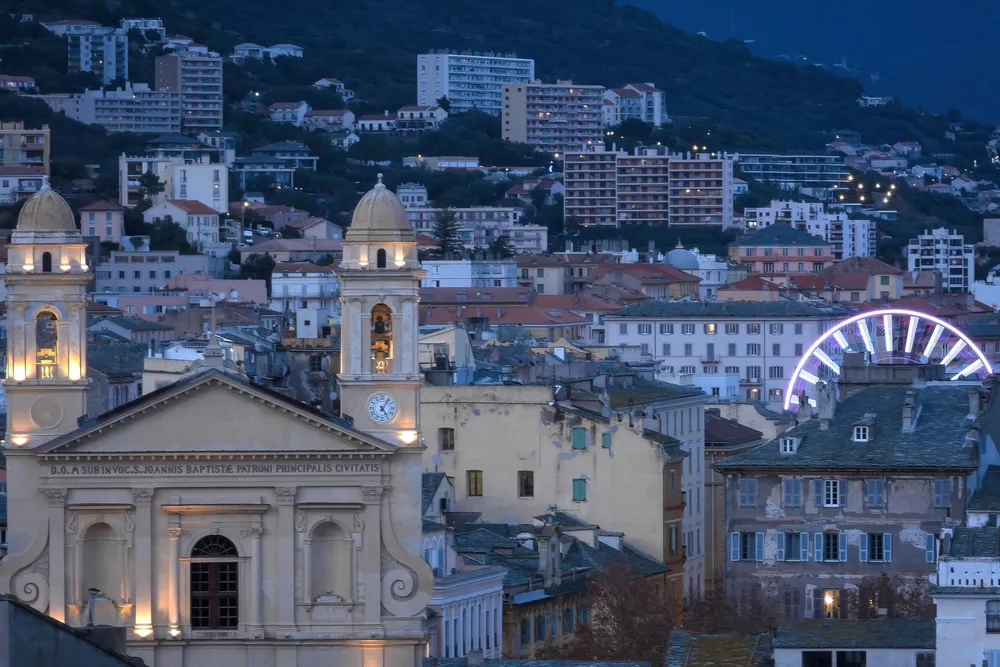 Bastia de noche, los campanarios de San Juan Bautista ante la ciudad iluminada