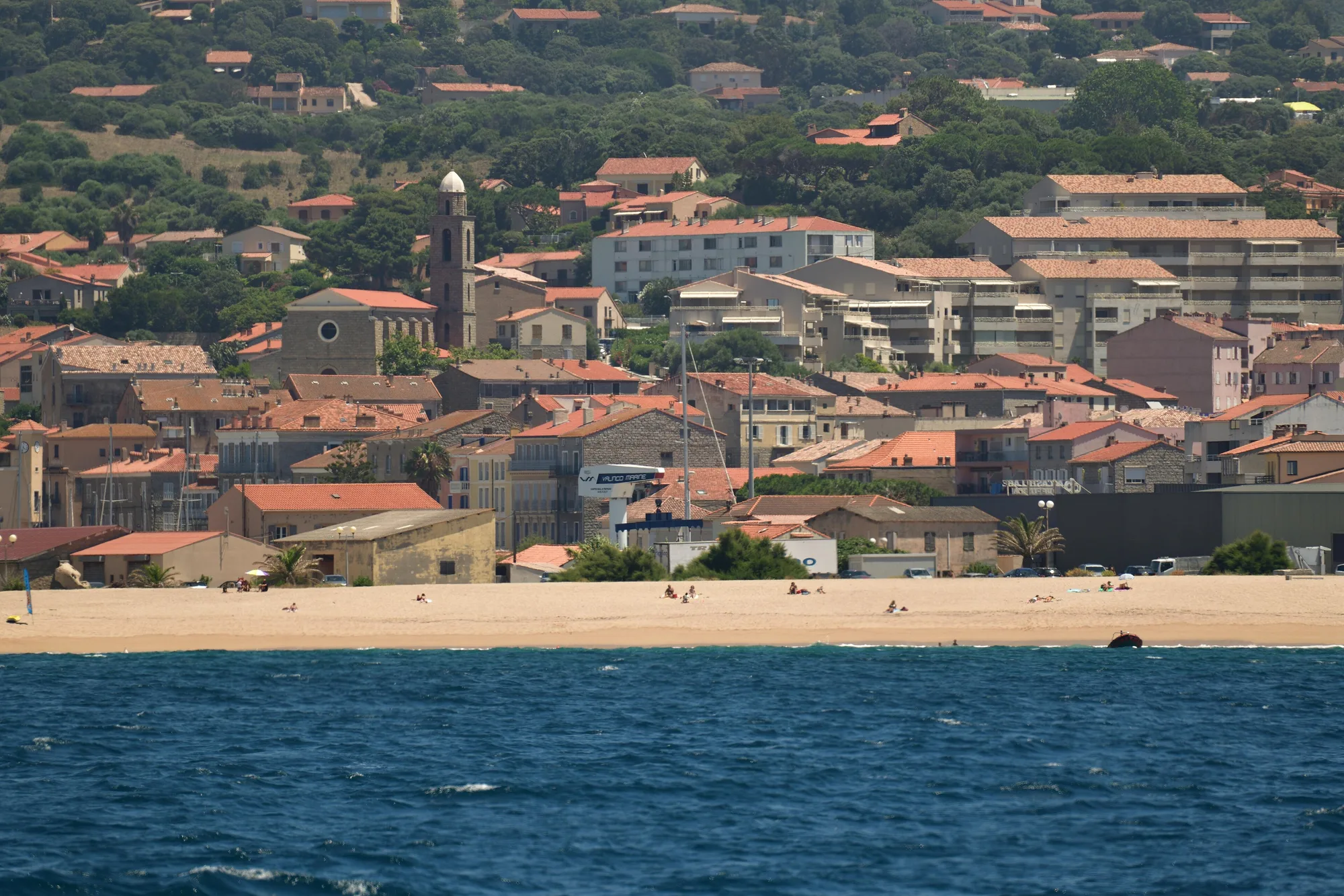 Propriano vue de la mer, la plage au pied des maisons et le clocher de l’église
