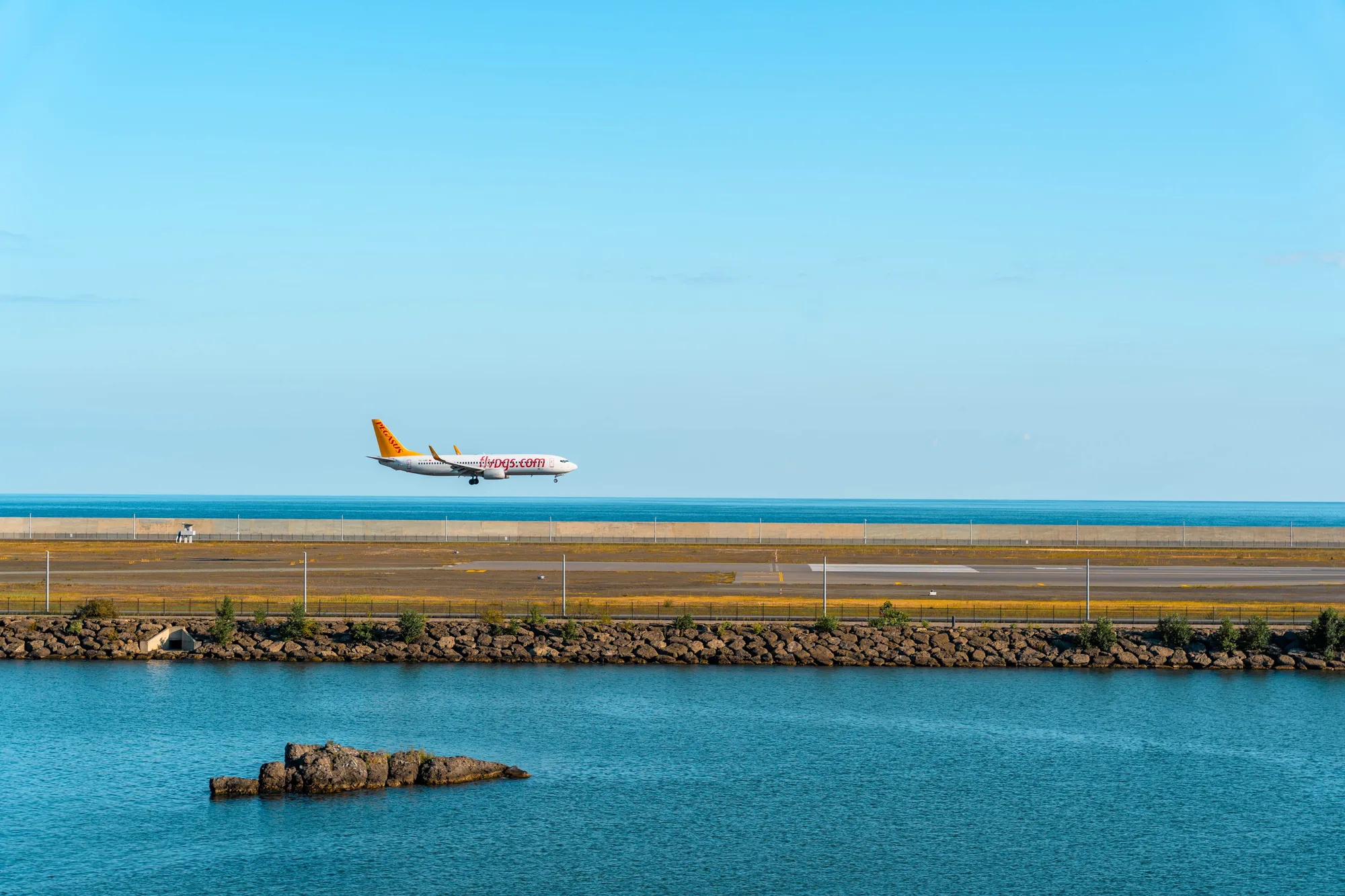 Un avion de ligne à l’approche d’une piste en bord de mer