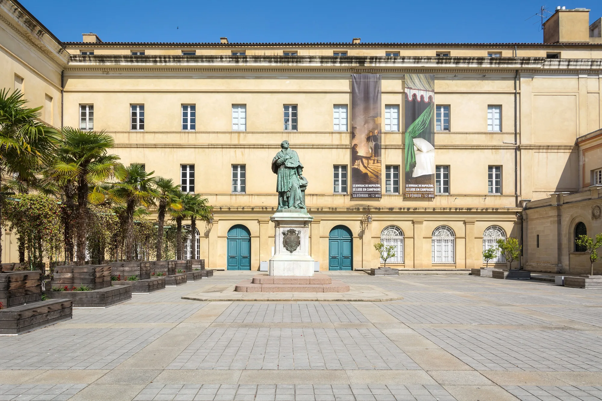 La façade du palais Fesch à Ajaccio, qui abrite le musée des Beaux-Arts, et la statue de la cour