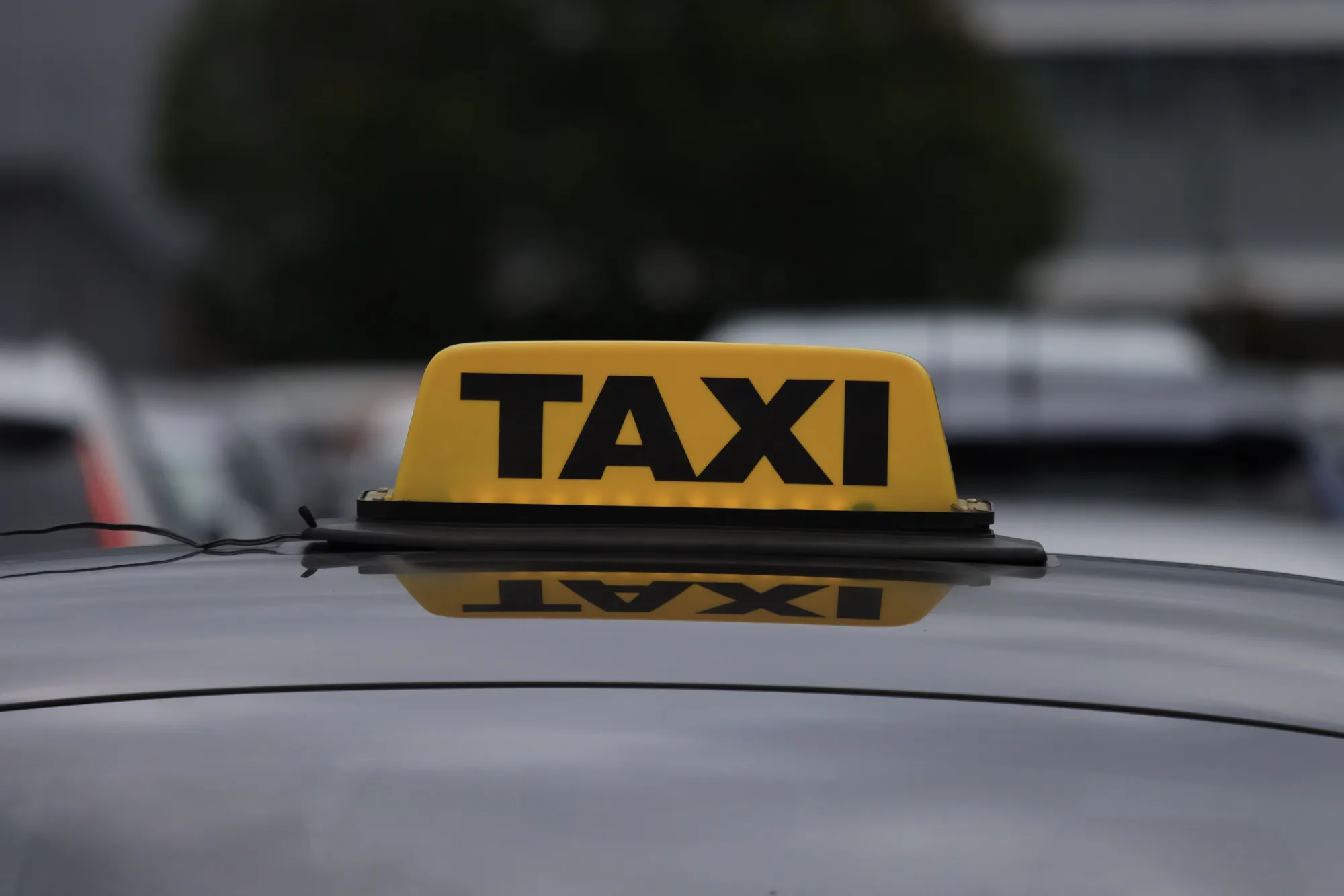 Une enseigne lumineuse de taxi sur le toit d’une voiture