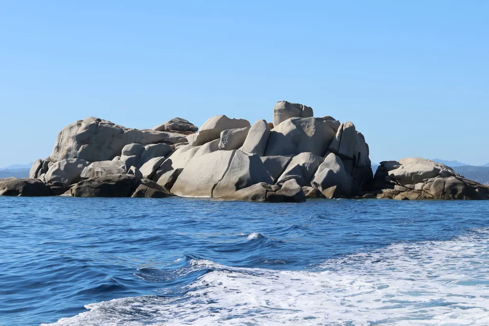 Un islote de granito en un mar agitado, visto desde un barco