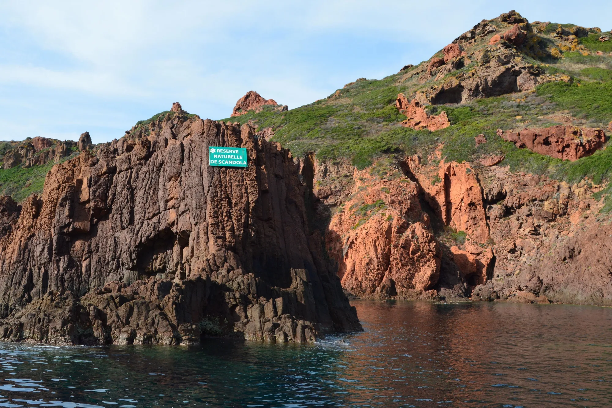 Falaises de roche rouge de la réserve de Scandola, avec le panneau de la réserve