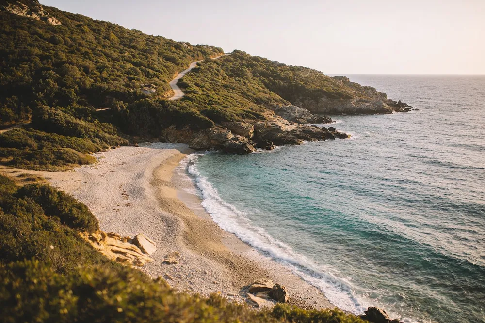 Ilustración de una pequeña playa salvaje entre dos puntas de maquis, en el norte del Cabo Corso
